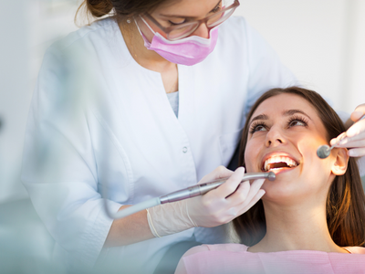 general dentistry photos showing a dentist inspecting a patient's mouth.